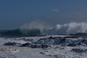 A huge wave driven by an approaching cyclone or hurricane, breaks and crashes wildly into the boiling storm surf, trailing wind blown spray as it breaks at Snapper Rocks on the Gold Coast, Australia.