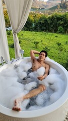 Handsome Man Relaxing in a Bubble Bath at a Chiang Mai Resort in his Honeymoon trip