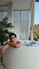 Handsome Man Relaxing in a Bubble Bath at a Chiang Mai Resort in his Honeymoon trip