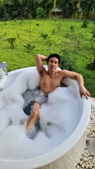 Handsome Man Relaxing in a Bubble Bath at a Chiang Mai Resort in his Honeymoon trip