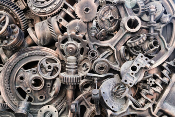 Metal gears background. Old and rusty spare parts for industrial machines in a landfill..