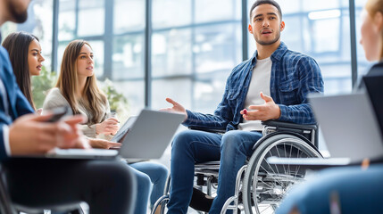 A young businessman with a disability holds a meeting in the office in front of the assembled employees.