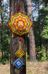 A mandala made of threads on a pillar.