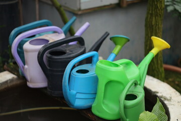 A collection of watering cans arranged on a table surface.