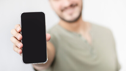 Man holds smartphone with blank black screen for mockup	