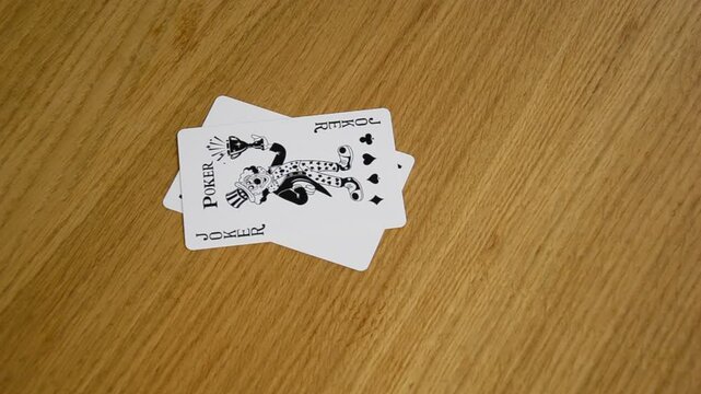 throwing playing cards on wooden table