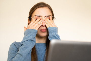 Overworked woman rubbing eyes due to dryness fatigue feeling headache having eyesight problems...