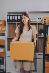 Asian SME business women use laptop computer checking customer order online shipping boxes at home....