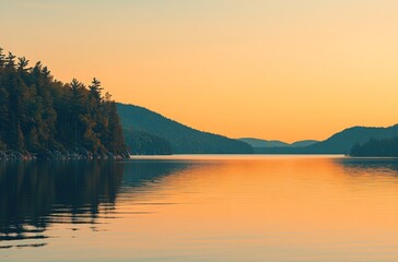 Fototapeta premium Beautiful lake with a forest and mountain background at sunset. Landscape photography of a natural scene in Canada. A panoramic view from the shore looking out over an emerald green