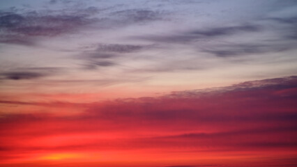 Fototapeta premium Dramatic sky with red, pink, and purple clouds at sunset, copy space. Nature background for design and print