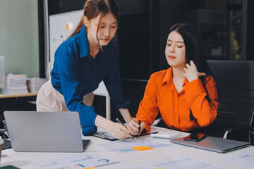 Entrepreneur Asian businessman and businesswoman discussing new business project in tablet in modern Meeting In Modern Office, Asian business casual concept.