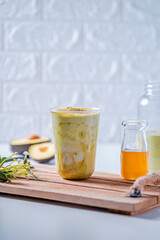 A glass of avocado smoothie with fresh honey