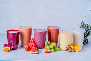 A set of cups of different fresh fruit juice