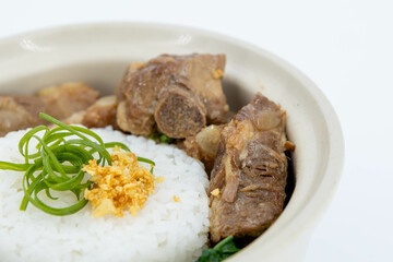 Braised Pork Ribs Rice Bowl on white background, Baked Pork Spare Ribs with Rice, Braised pork ribs rice bowl presented in white ceramic bowl, Asian-style braising sauce, Thaifood