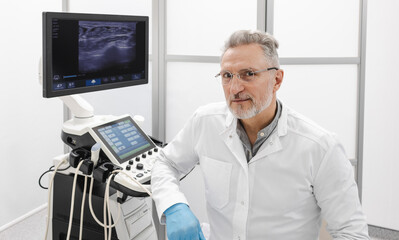 Ultrasound technician in modern medical clinic with diagnostic ultrasound machine for checking of...