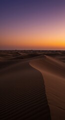 Naklejka premium Desert Sand Dune Landscape at Dusk with Warm Orange Sky