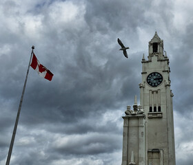 Clock Tower and Canadian Flag under Dramatic Sky in Montreal