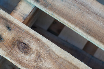 Close-up of weathered wooden pallet slats, showing the natural grain and texture of the wood.
