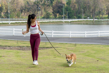 A woman is walking her dog in a park