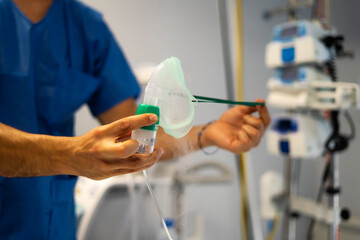 Doctor holding oxygen mask with nebulizer in hospital room