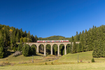 Modern diesel train, railway bridge Chramossky viadukt near Telgart, Horehronie, Slovakia