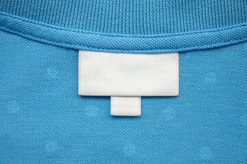 White blank laundry care clothes label on shirt fabric background