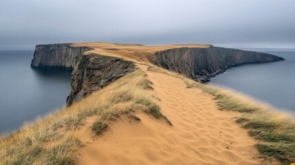 Sandy Isthmus Connecting Dark Cliff To Mainland Under Hazy Sky