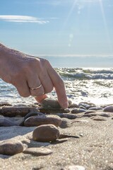 Pebble tower on sunny beach sea wave splashing water balance pyramid harmony equilibrium peace of mind. Cobblestone formation construction seaside