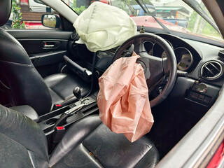Airbag is currently hanging from the steering wheel of a car 