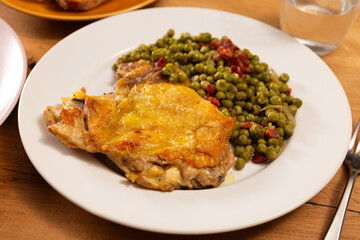 Delicious crispy chicken with peas as a side dish on a plate