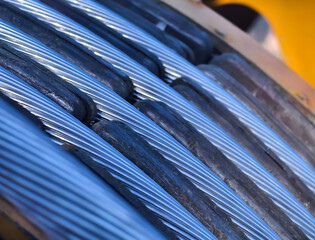 A large wooden spool of high-voltage electric wires is located on the road