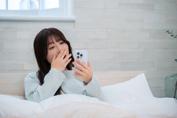 あくびをしながらスマホを見る日本人女性