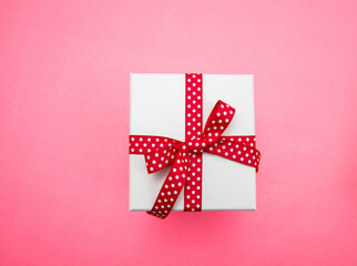 Gift box white, red ribbon bow with dots, top view. Christmas present
