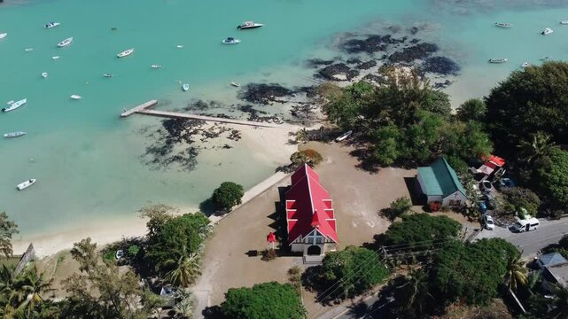 Stunning aerial view of Gunner's Quoin (Coin de Mire) Island and the iconic red-roofed church on the beach at Cap Malheureux, Mauritius