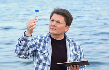 Middle aged man ecologist. Learned biologist makes notes on the state of the flora and fauna of the...