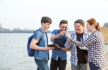 Four people study the problems of ecology, environmental pollution. Group of students are an...