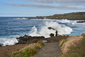 Waves crashing against volcanic rocks........