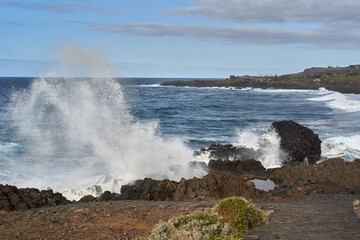 Waves crashing against volcanic rocks........
