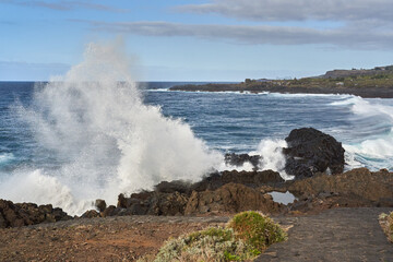 Waves crashing against volcanic rocks........