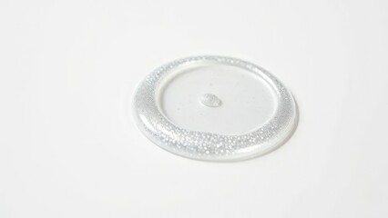 Shimmering silver lip gloss falls on white surface, shine, metallic, shine