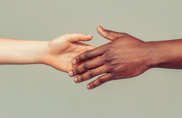 Woman and man holding hands together. Woman and african woman hand. Giving a helping hand to another