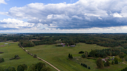 Naklejka premium Aerial View of Rural Landscape with Green Fields and Clouds