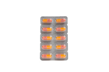 Blister pack with orange and pink capsules on isolated white background. Close up of colorful pills. Health, pharmaceutical, medical and treatment concept