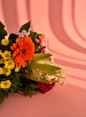 a bouquet of various summer wild flowers on a delicate pink background in the form of a frame with a place for text. High quality photo