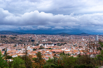 Fototapeta premium Dramatic Cloudy Sky Over Sucre Bolivia Panoramic View Of The White City With Its Traditional Rooftops And Historic Landmarks Under A Stormy Horizon
