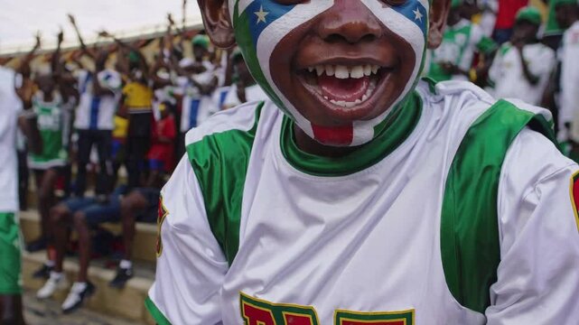 Young South Sudanese Fan with Face Painted in National Colors at a Sports Event