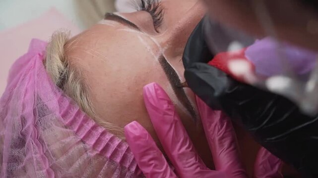 Close-up of a girl's eyebrow tattoo. Permanent eyebrow makeup, performing eyebrow tattoo PMU