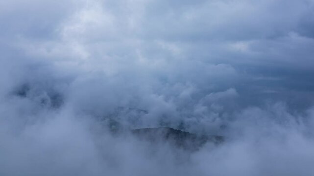 タイムラプス　雨の日の山頂を、覆いかぶさりながら流れていく雨雲