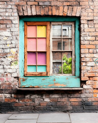 Colorful window on a weathered brick wall