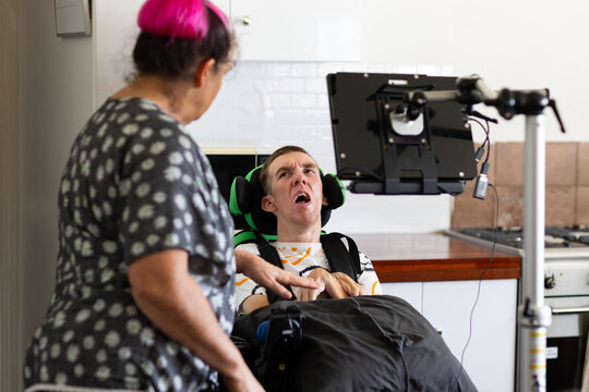 Middle age woman talking to her son with disability on a wheelchair.